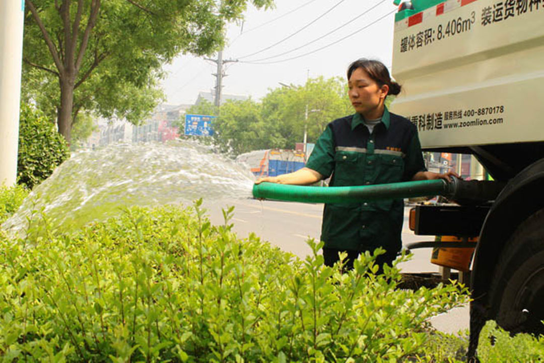 怡轩园林绿化公司工人正在进行植物浇灌工作